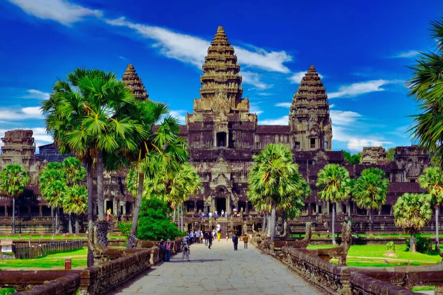 Tourists walking through palm-lined entrance leading to Angkor Wat, Cambodia – Auasia Travel